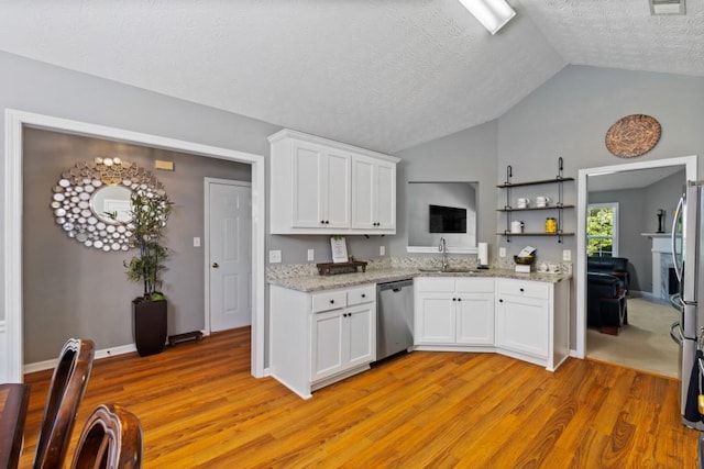 kitchen with lofted ceiling, white cabinetry, a textured ceiling, sink, and stainless steel appliances