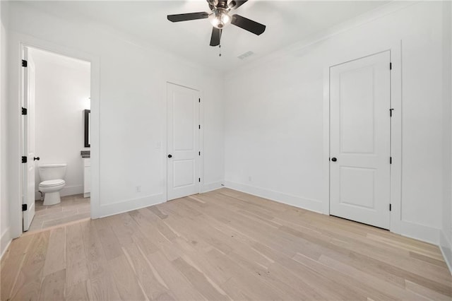 unfurnished bedroom featuring ceiling fan, ensuite bath, and light hardwood / wood-style flooring