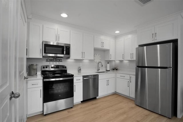 kitchen featuring a sink, light countertops, white cabinets, and stainless steel appliances
