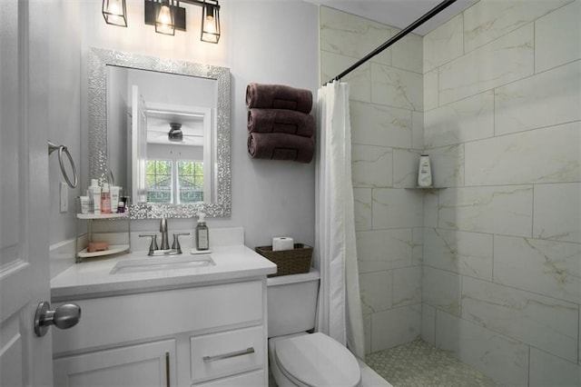 bathroom featuring vanity, a ceiling fan, toilet, and tiled shower