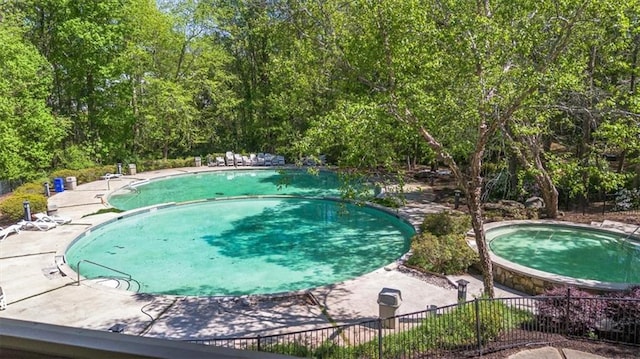 view of pool with a fenced in pool, a jacuzzi, fence, and a patio area