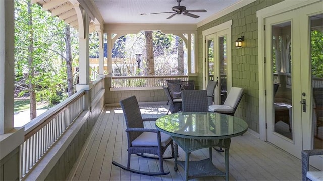sunroom with a wooden deck, wood-type flooring, french doors, and a wealth of natural light