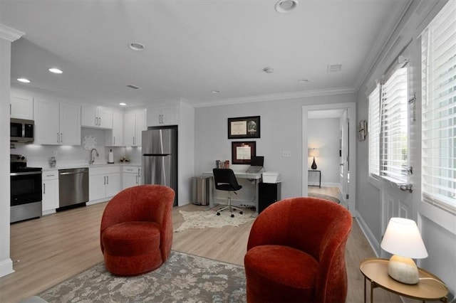 living room featuring recessed lighting, baseboards, crown molding, and light wood finished floors