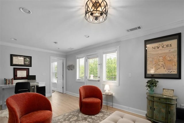 living area featuring baseboards, visible vents, ornamental molding, and wood finished floors