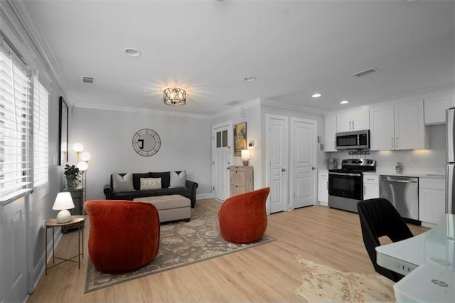 living room with crown molding, light wood-style floors, recessed lighting, baseboards, and visible vents