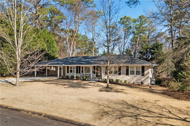 single story home featuring an attached carport and dirt driveway