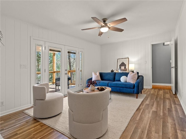 living room featuring wood finished floors, baseboards, french doors, and ceiling fan