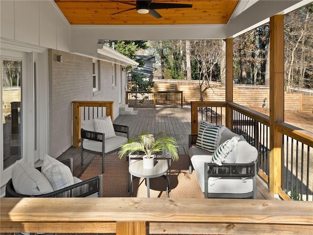 wooden terrace featuring ceiling fan, outdoor lounge area, and fence