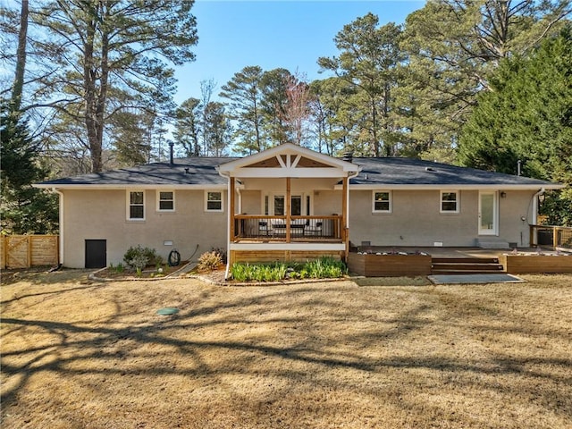 back of property with crawl space, stucco siding, a deck, and fence