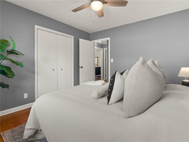 bedroom featuring a closet, ceiling fan, baseboards, and wood finished floors