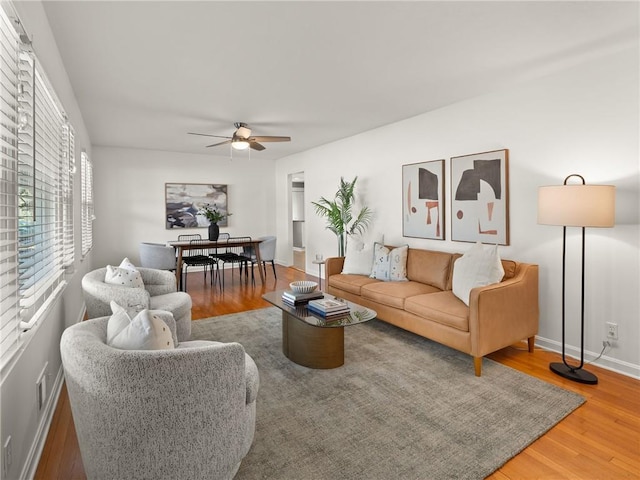 living room with wood finished floors, baseboards, and ceiling fan