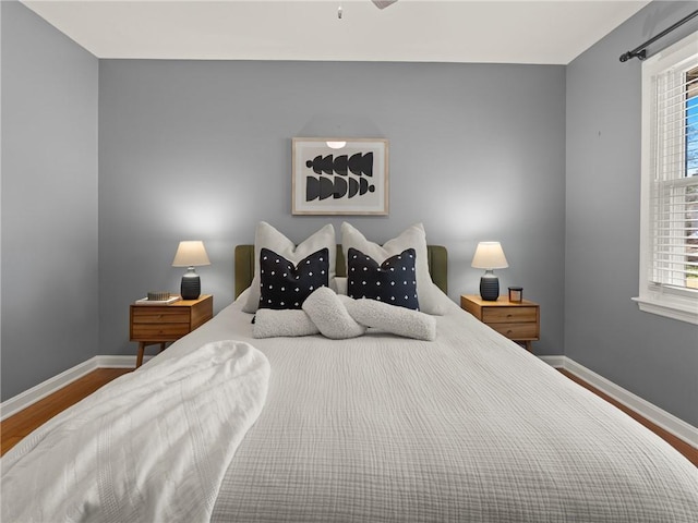 bedroom featuring baseboards and wood finished floors