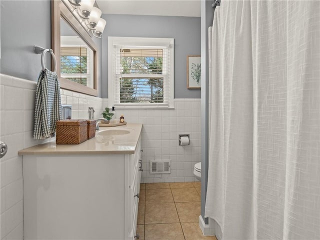 bathroom featuring tile patterned floors, visible vents, toilet, wainscoting, and vanity