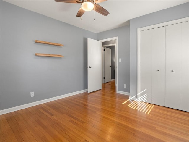 unfurnished bedroom with light wood-style flooring, baseboards, a closet, and ceiling fan