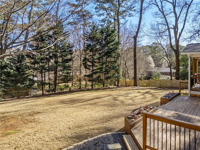 view of yard with a wooden deck and fence