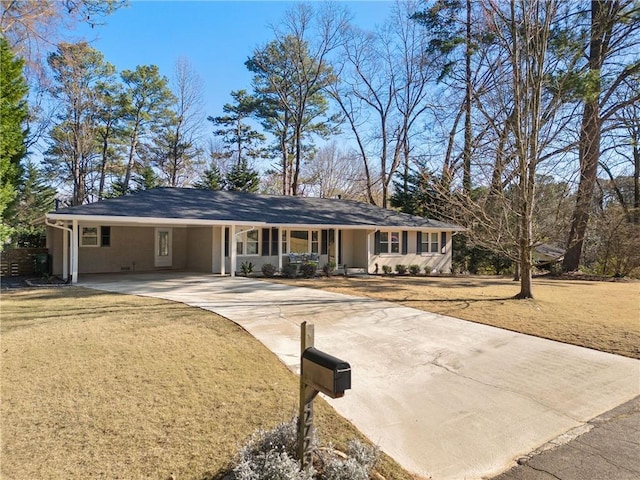 ranch-style home with an attached carport, concrete driveway, and a front lawn