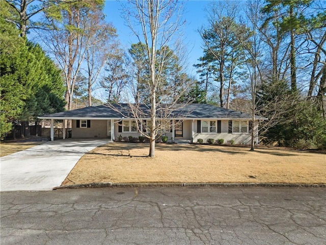 single story home featuring an attached carport, concrete driveway, and a front lawn