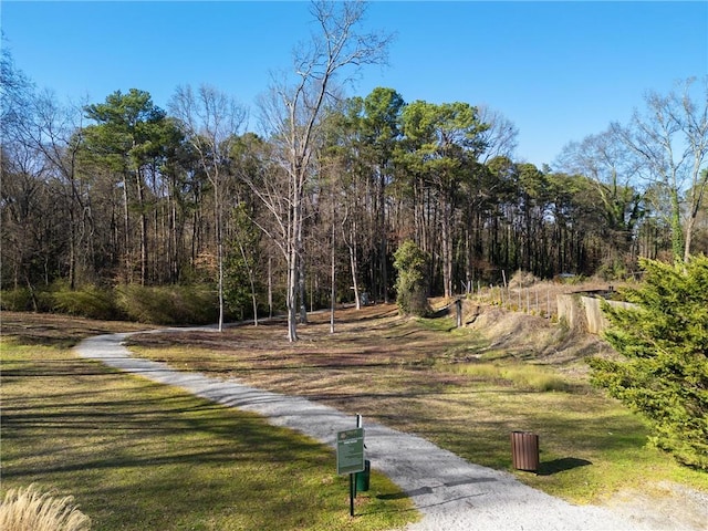 surrounding community featuring a wooded view and a yard