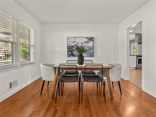 dining area with visible vents, baseboards, and light wood-style floors