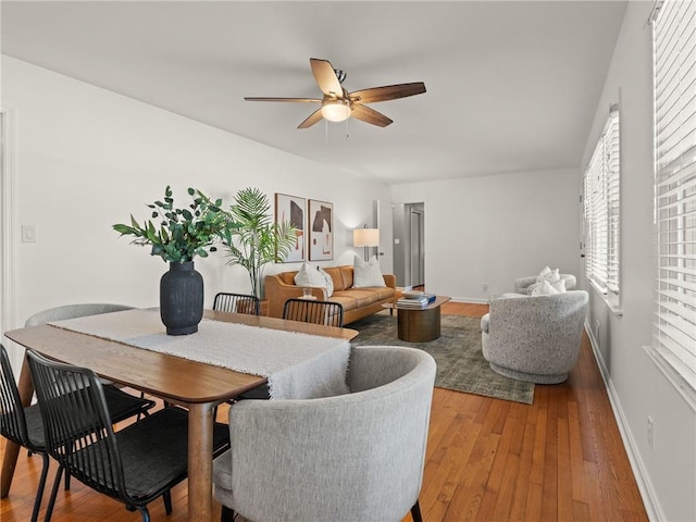 dining space with hardwood / wood-style flooring, baseboards, and ceiling fan