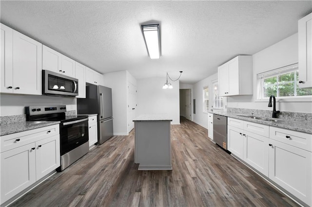 68 Wagon Trail Cir, Dallas, GA 30132 - kitchen featuring stainless steel appliances, a center island, dark wood-type flooring, white cabinets, and a textured ceiling