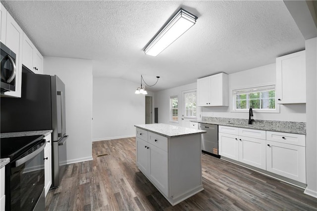 68 Wagon Trail Cir, Dallas, GA 30132 - kitchen with stainless steel dishwasher, range with electric cooktop, a kitchen island, dark wood-type flooring, and a textured ceiling