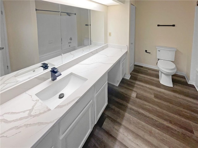 bathroom featuring toilet, hardwood / wood-style flooring, walk in shower, and vanity