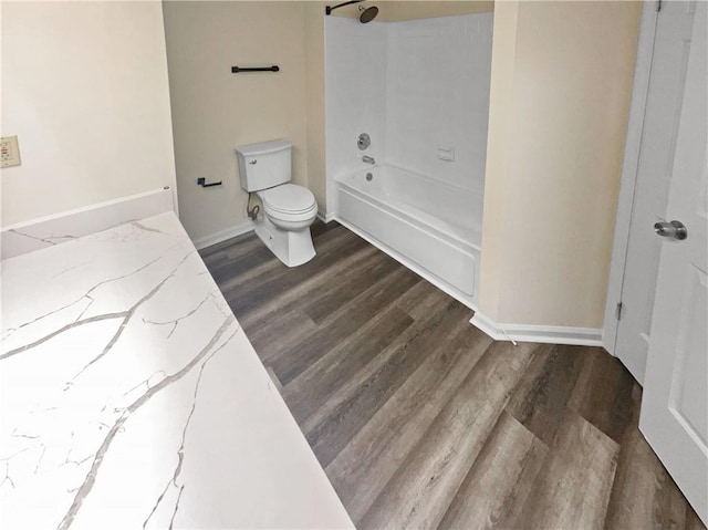 bathroom featuring toilet,  shower combination, and wood-type flooring