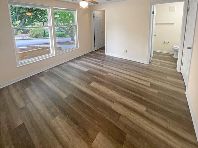 unfurnished bedroom with ensuite bath, ceiling fan, and dark hardwood / wood-style floors