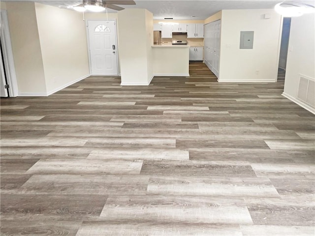 unfurnished living room with electric panel, dark wood-type flooring, and ceiling fan