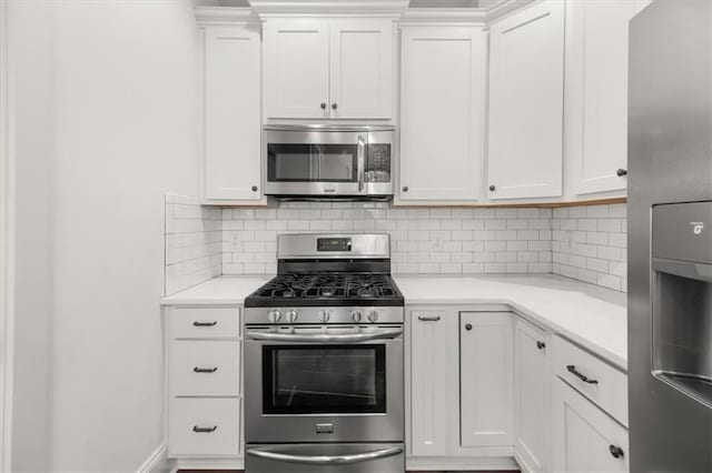 kitchen with appliances with stainless steel finishes, light countertops, decorative backsplash, and white cabinetry