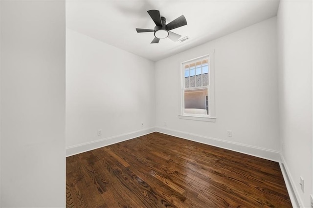 spare room featuring ceiling fan, visible vents, baseboards, and wood finished floors