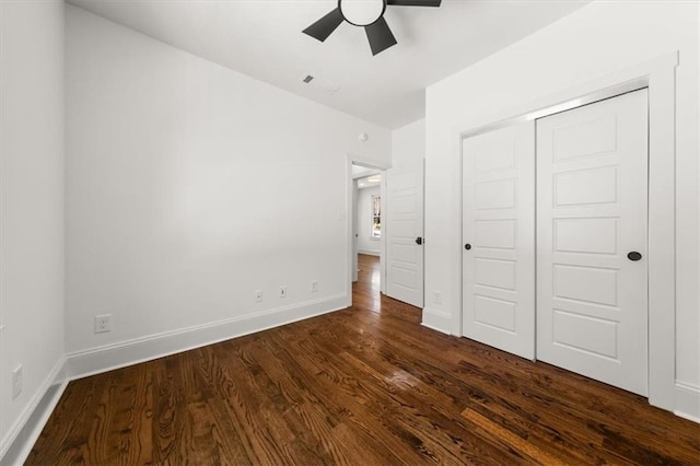 unfurnished bedroom featuring visible vents, baseboards, dark wood finished floors, ceiling fan, and a closet