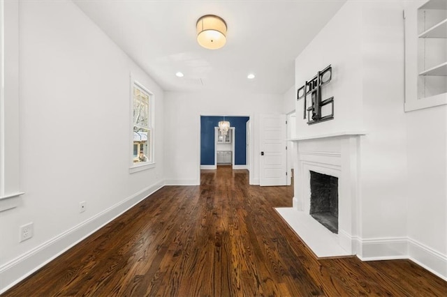 unfurnished living room featuring a fireplace with flush hearth, baseboards, dark wood-type flooring, and recessed lighting