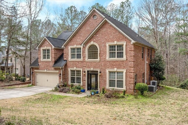 colonial-style house featuring concrete driveway, a garage, brick siding, and a front yard