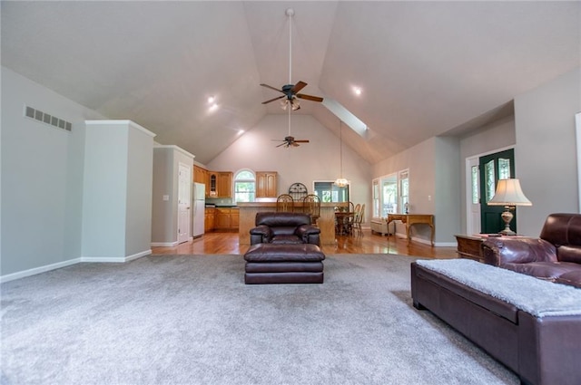 1775 Whooping Creek Rd, Carrollton, GA 30116 - living area featuring high vaulted ceiling, light colored carpet, ceiling fan, a chandelier, and a skylight