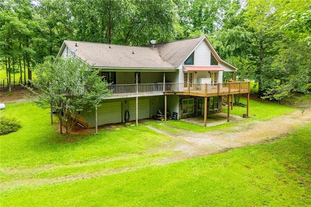 1775 Whooping Creek Rd, Carrollton, GA 30116 - back of house featuring dirt driveway, a deck, a lawn, an attached garage, and view of wooded area