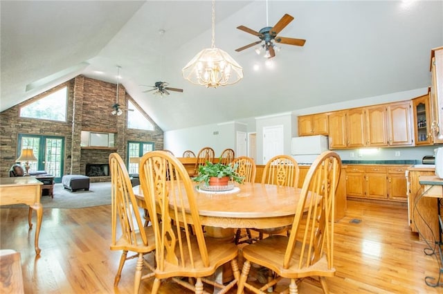 1775 Whooping Creek Rd, Carrollton, GA 30116 - dining room featuring ceiling fan, light wood-style floors, high vaulted ceiling, and a fireplace