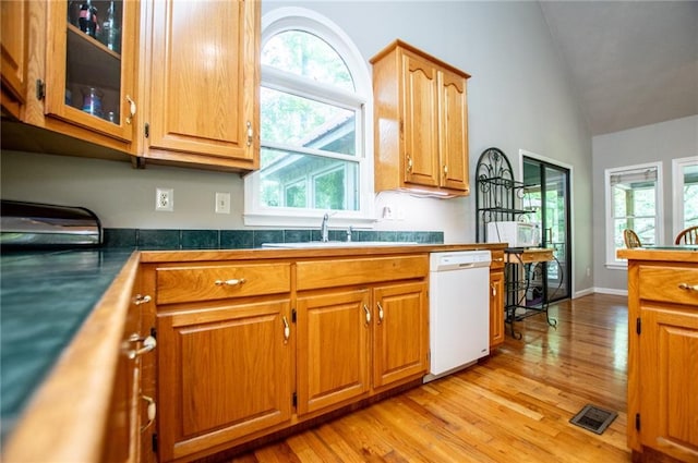 1775 Whooping Creek Rd, Carrollton, GA 30116 - kitchen with white dishwasher, vaulted ceiling, light wood finished floors, glass insert cabinets, and brown cabinets