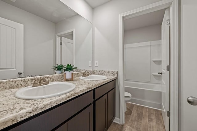 full bathroom featuring vanity, bathtub / shower combination, hardwood / wood-style floors, and toilet