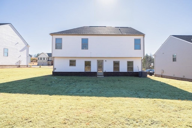 rear view of house featuring a lawn and central air condition unit