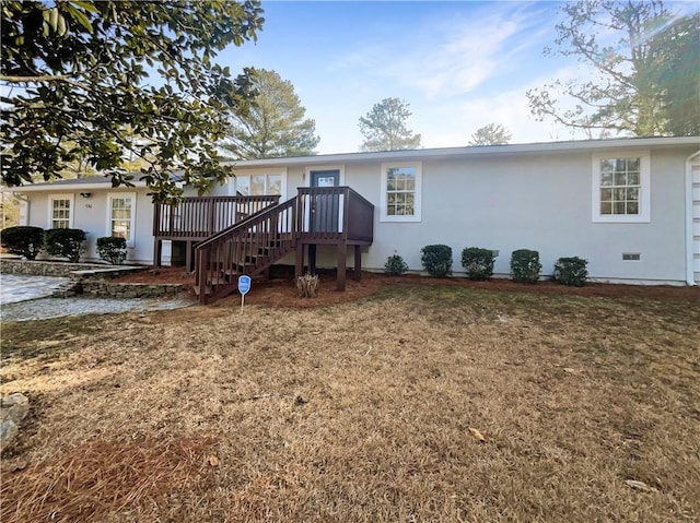 view of front of house with a front yard and a deck