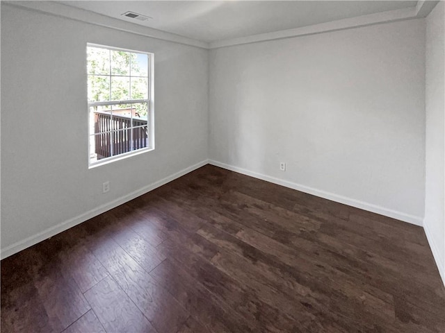 spare room featuring crown molding and dark hardwood / wood-style floors