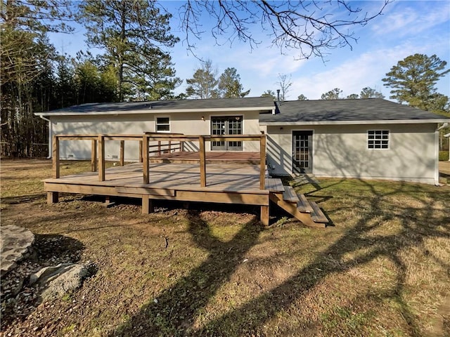 back of house featuring a wooden deck and a lawn