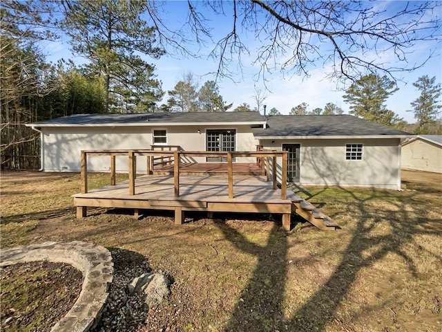 back of property with a wooden deck and a yard