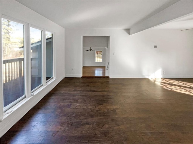 unfurnished living room with beam ceiling, dark hardwood / wood-style floors, and ceiling fan