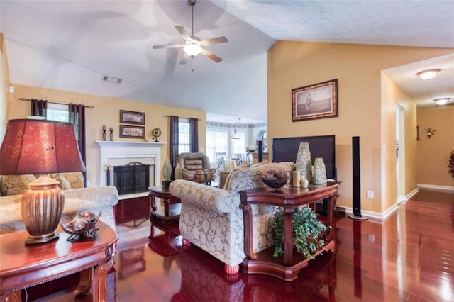 living area featuring wood finished floors, a healthy amount of sunlight, a fireplace, and vaulted ceiling