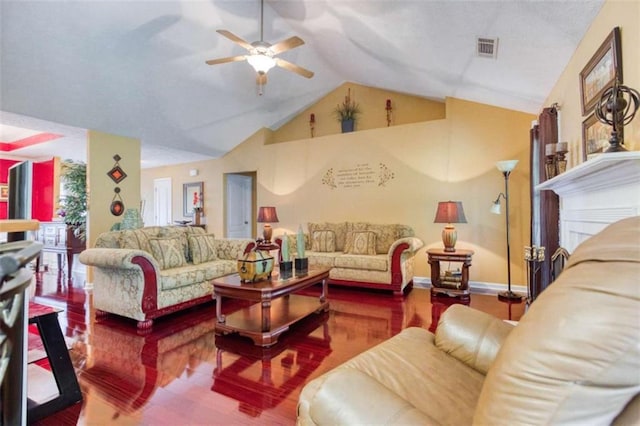 living area with a ceiling fan, visible vents, vaulted ceiling, baseboards, and wood finished floors