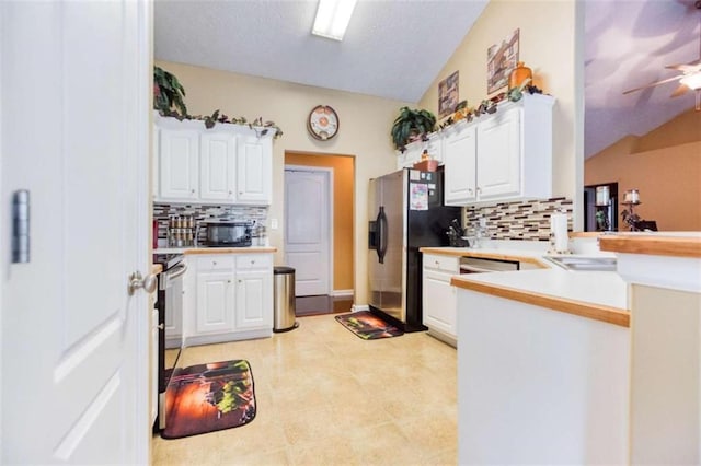 kitchen featuring white cabinetry, stainless steel fridge, and backsplash