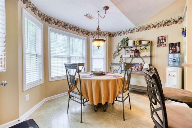 dining area with baseboards, visible vents, and lofted ceiling